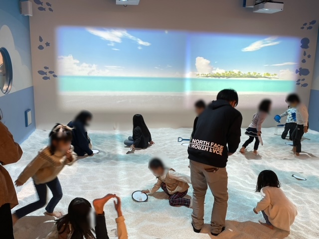 あそびパークプラス内屋内砂浜海の子で遊ぶ子供たちの写真